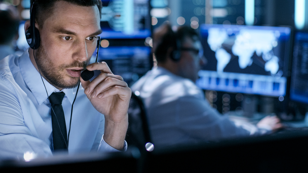 In Monitoring Room Technical Support Specialist Speaks Into Headset