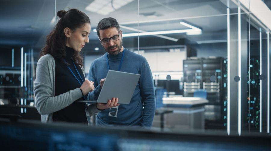 Portrait Of Two Female And Male Engineers Using Laptop Computer