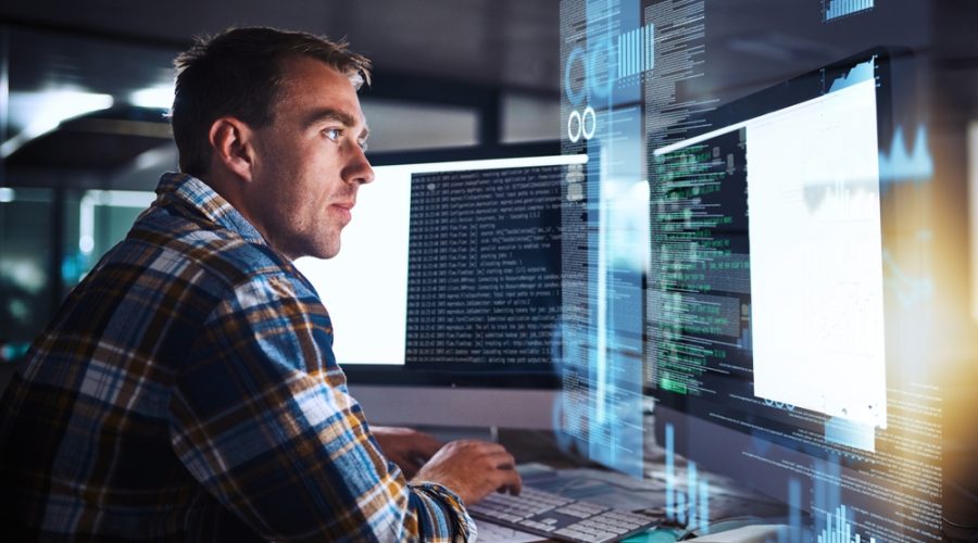 Man working on computer with tech graphic overlay